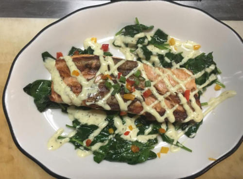 photo of Salmon Special featuring pan seared salmon, special sauce and sauteed spinach